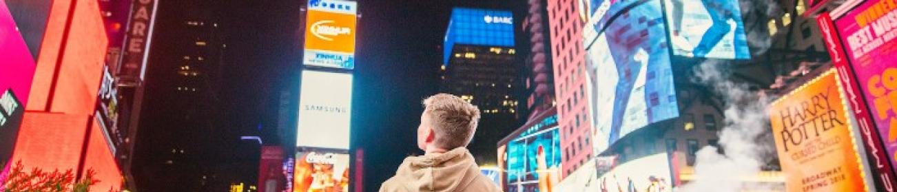 Jeune homme au milieu de panneaux publicitaires